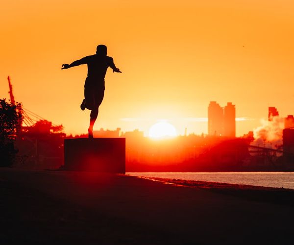 Man stretching outdoors at sunrise feeling refreshed and energetic.